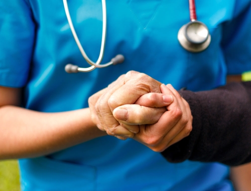 nurse holding patient's hand